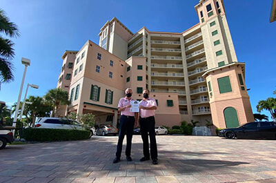 Pink Shell team members hold certificate in front of resort