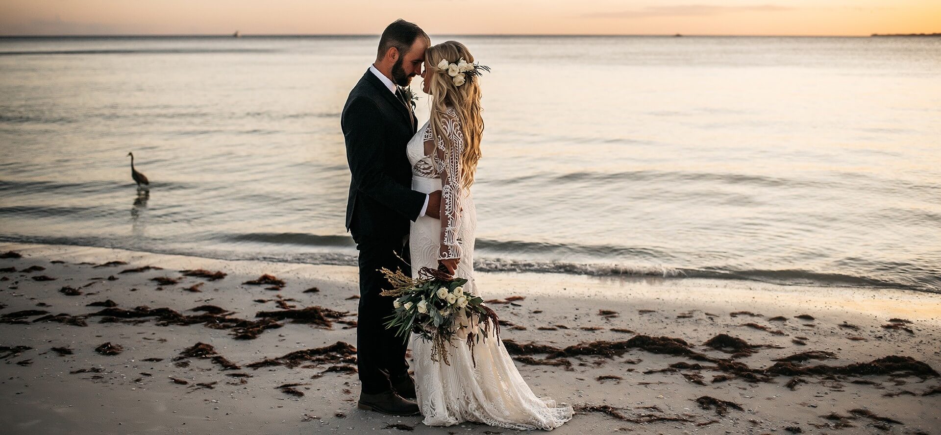 A bride and groom take wedding photos on the beach