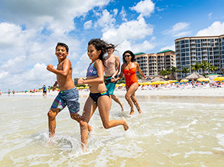 Family playing on the private beach at Pink Shell Resort