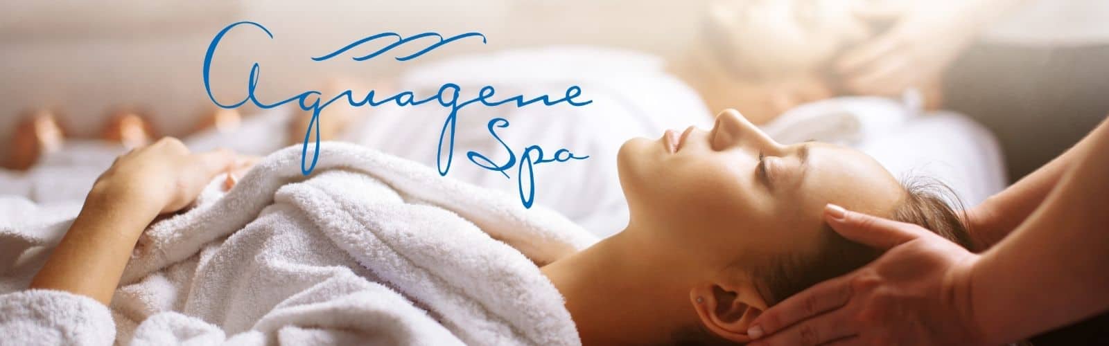 A person in a white robe receives a head massage at a spa, with another person in the background; “Aquagene Spa” is written in blue script across the image.
